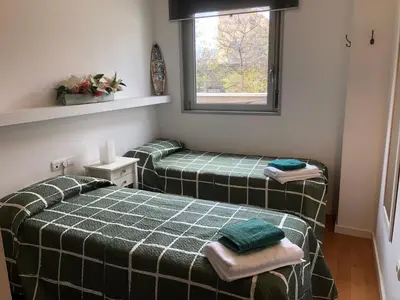 two green beds in a room with a window at Apartamento Barcelona CCIB-Playa-Diagonal mar in Barcelona