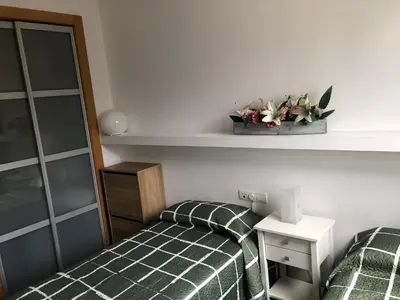 a bedroom with two beds and a shelf with flowers at Apartamento Barcelona CCIB-Playa-Diagonal mar in Barcelona