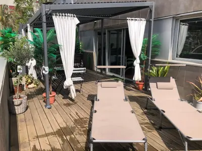 a patio with white curtains and chairs on a deck at Apartamento Barcelona CCIB-Playa-Diagonal mar in Barcelona