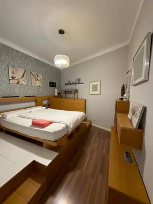 a bedroom with a large bed with a wooden frame at Cozy Apartment in the Center Area Sagrada Familia in Barcelona
