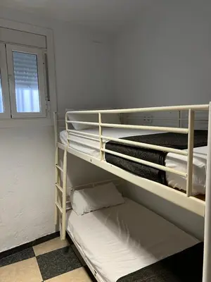 a room with two bunk beds and a window at Habitaciones Carmen in Rubí