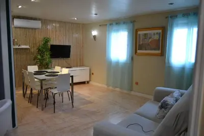 a living room with a table and chairs and a television at Estancia perfecta, apartamento bonito in Hospitalet de Llobregat