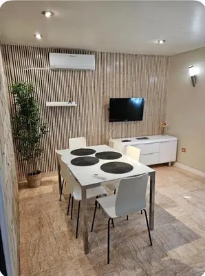 a dining room with a white table and chairs at Estancia perfecta, apartamento bonito in Hospitalet de Llobregat
