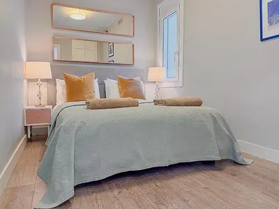 a bedroom with a bed with two lamps and a mirror at Bonaire Penthouse Sitges 2 terraces steps from beach in Sitges