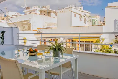 a white table with glasses and a plant on a balcony at Bonaire Penthouse Sitges 2 terraces steps from beach in Sitges
