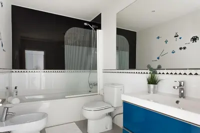 a white bathroom with a toilet and a sink at Catalan Music Palace with private terrace in Barcelona