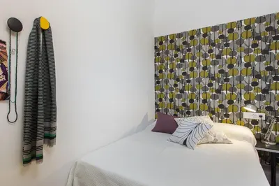 a bedroom with a white bed with a wall at Catalan Music Palace with private terrace in Barcelona