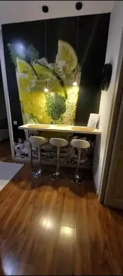 a table with two stools in front of a painting of fruit at Great location with private terrace in Barcelona