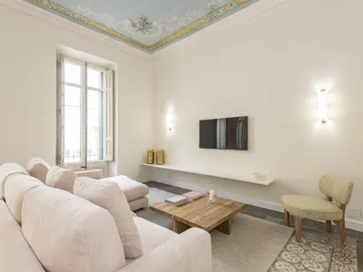 a living room with a couch and a tv on a wall at The Residences At Bartomeu 26 Suite Bartomeu in Sitges