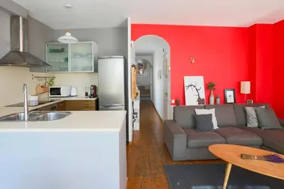 a kitchen and a living room with red walls at Barcelona Attic center 2 Terraces Magic views in Barcelona