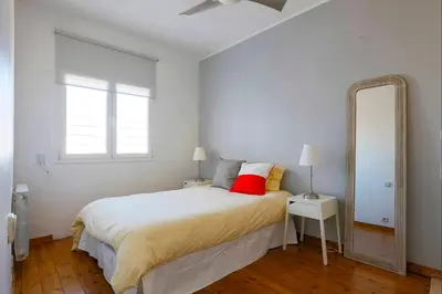 a bedroom with a bed with a red pillow and a mirror at Barcelona Attic center 2 Terraces Magic views in Barcelona