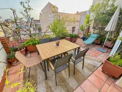 a patio with a wooden table and chairs on a balcony at Barcelona Attic center 2 Terraces Magic views in Barcelona