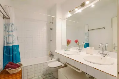 a bathroom with two sinks and a toilet and a tub at Barcelona Attic center 2 Terraces Magic views in Barcelona