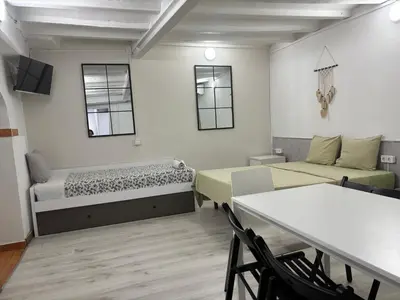 a room with two beds and a table and chairs at 019 principal floor in Barcelona