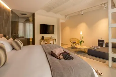 a bedroom with a large bed and a living room at Ohla Eixample in Barcelona