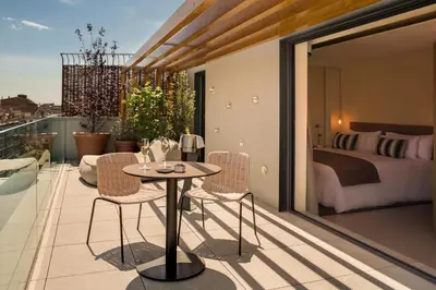 a balcony with a table and chairs and a bedroom at Ohla Eixample in Barcelona