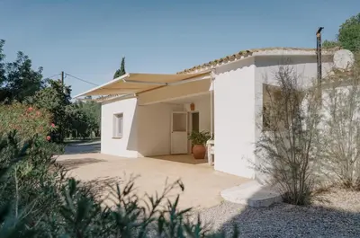 a white house with a driveway at Masia Can Pares in Sant Pere de Ribes