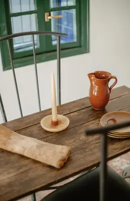 a wooden table with a candle and a cup on it at Masia Can Pares in Sant Pere de Ribes