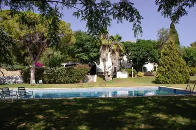 a swimming pool in the yard of a house at Masia Can Pares in Sant Pere de Ribes