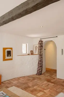 a living room with white walls and a wooden ceiling at Masia Can Pares in Sant Pere de Ribes