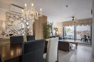 a dining room with a table and a chandelier at Attic Center Sitges in Sitges