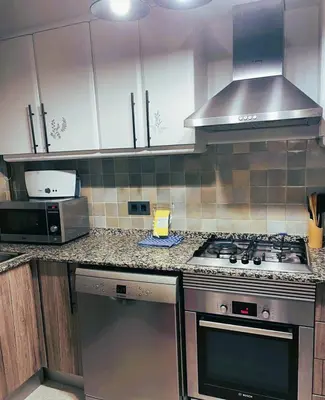 a kitchen with a stove and a microwave at Attic Center Sitges in Sitges
