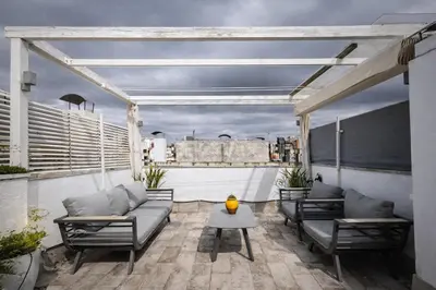 a patio with couches and a table on a roof at Attic Center Sitges in Sitges