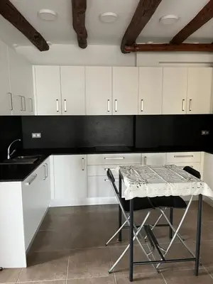 a kitchen with white cabinets and a table at La Casa Vella