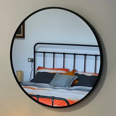 a mirror reflecting a bed with pillows on it at La Casa Vella