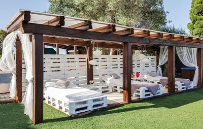 a wooden gazebo with beds in the grass at Gorgeous Home In Olerdola With Private Swimming Pool, Can Be Inside Or Outside in Olerdola