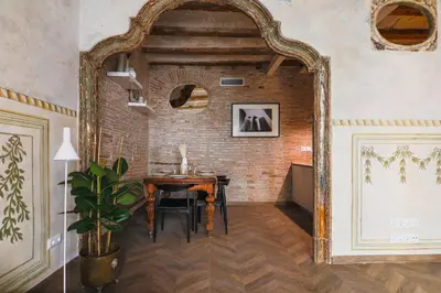 a dining room with a table and a brick wall at En Ville Boutique Apartments Boqueria Market in Barcelona