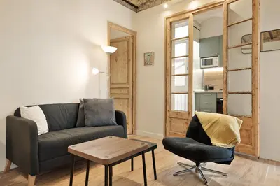 a living room with a couch and a chair at Enjoy Apartments VP Camp Nou 1 in Barcelona