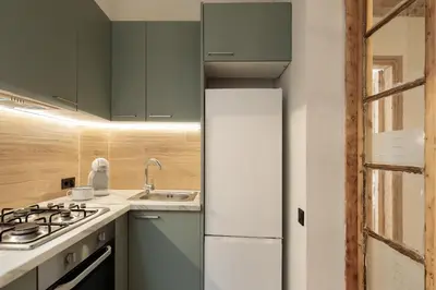 a kitchen with green cabinets and a white refrigerator at Enjoy Apartments VP Camp Nou 1 in Barcelona