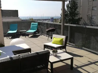 a patio with chairs and tables on a roof at Holiday Home Haus Terrassa de Mar direkt am Strand by Interhome in Masnou