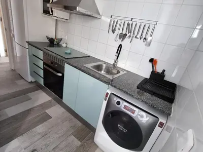 a kitchen with a washing machine next to a sink at Holiday Home Haus Terrassa de Mar direkt am Strand by Interhome in Masnou