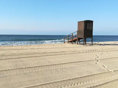a bench on the beach with the ocean in the background at Holiday Home Haus Terrassa de Mar direkt am Strand by Interhome in Masnou