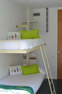 two bunk beds in a room with green pillows at Holiday Home Haus Terrassa de Mar direkt am Strand by Interhome in Masnou
