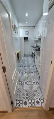 a kitchen with a black and white tile floor at 2-bedroom Bright and Classic Sagrada Familia Apartment in Barcelona