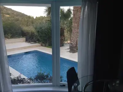 a view of a swimming pool through a window at Las Buganvillas in Castelldefels