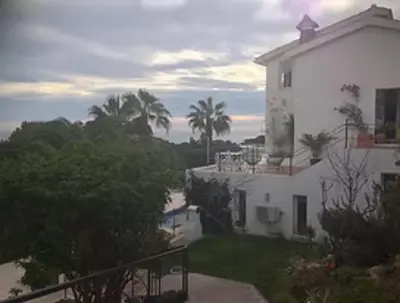 a white house with palm trees in front of it at Las Buganvillas in Castelldefels