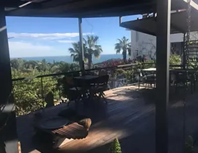 a balcony with a table and chairs and an umbrella at Las Buganvillas in Castelldefels