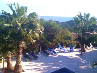 a group of lounge chairs and palm trees on a patio at Las Buganvillas in Castelldefels