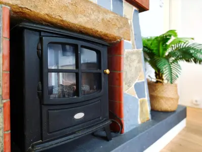 a black wood stove in a room with a plant at Apartamento en Vilassar de Mar, Costa de Barcelona in Vilassar de Mar