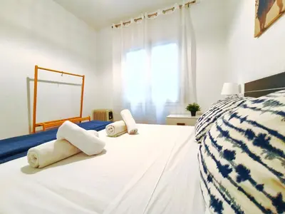 a bedroom with a white bed with towels on it at Apartamento en Vilassar de Mar, Costa de Barcelona in Vilassar de Mar