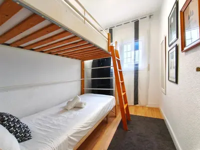 a small bedroom with a bunk bed and a ladder at Apartamento en Vilassar de Mar, Costa de Barcelona in Vilassar de Mar