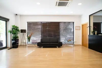 a living room with a black couch in a room at Hotel Cim Valles in Santa Perpetua de Moguda