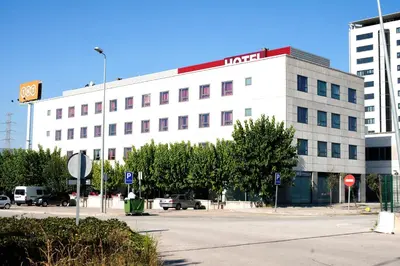a large white building with a hotel sign on it at Hotel Cim Valles in Santa Perpetua de Moguda