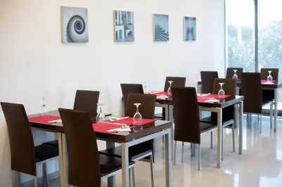 a dining room with tables and chairs with wine glasses on them at Hotel Cim Valles in Santa Perpetua de Moguda