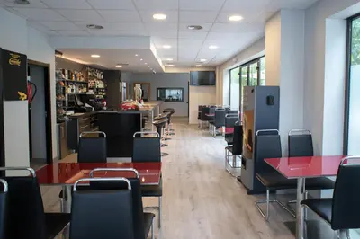 a dining room with tables and chairs and a counter at Hotel Cim Valles in Santa Perpetua de Moguda