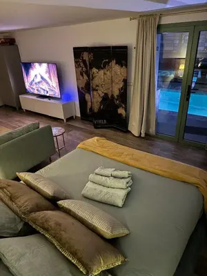 a living room with a bed and a television at Suite with Pool Barcelona in Vilassar de Dalt